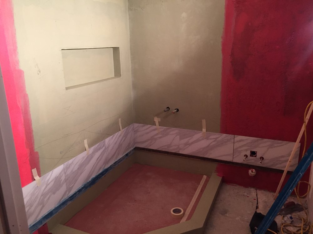 Tile installation underway in a mobile home bathroom