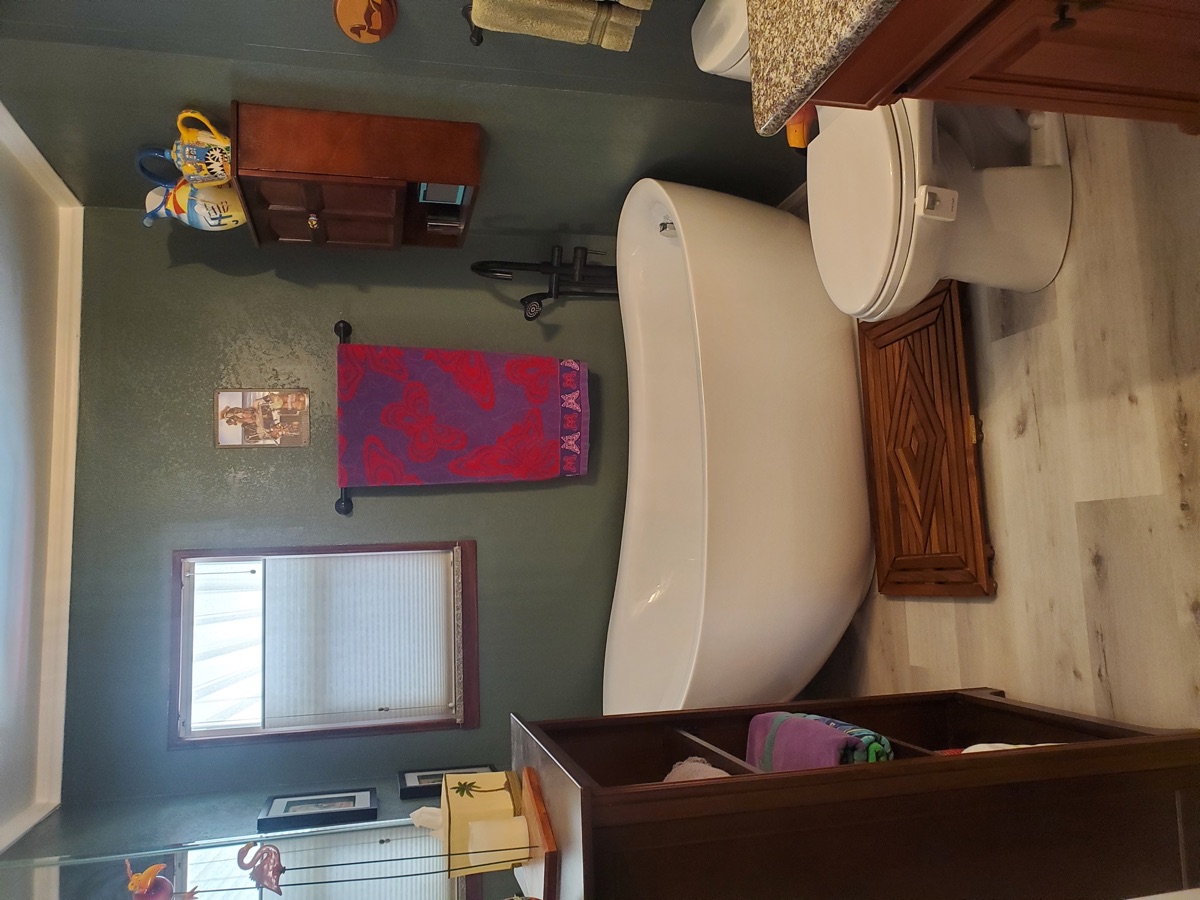 Standalone bathtub remodel with updated surround and fixtures in a mobile home bathroom