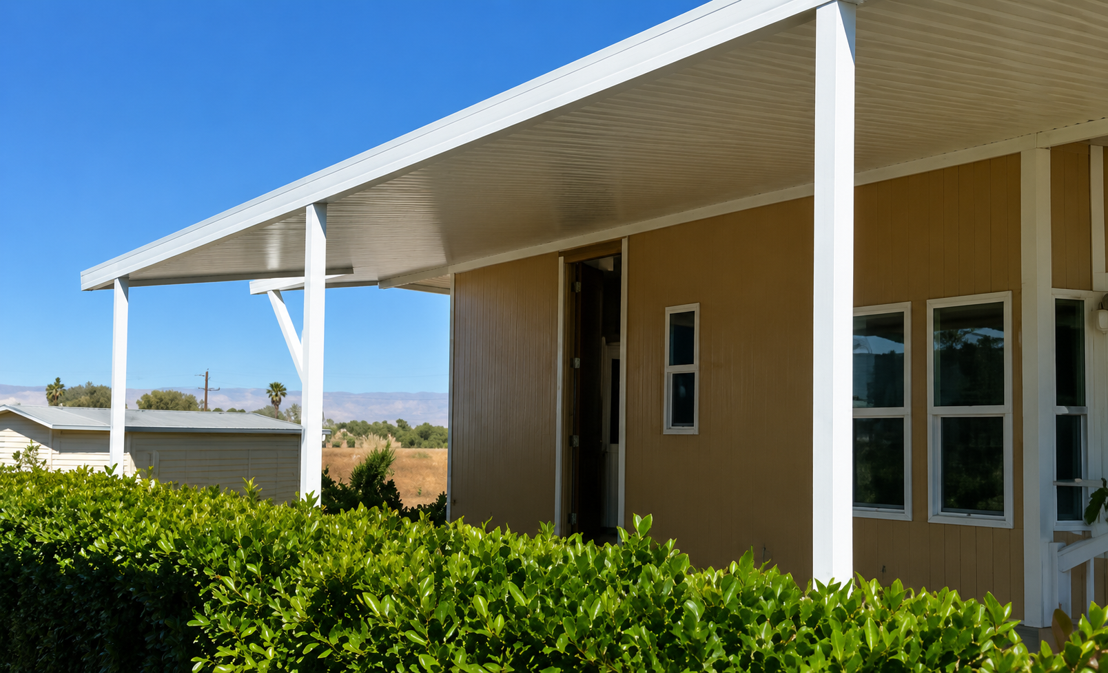 White metal patio cover and awning installed on a mobile home