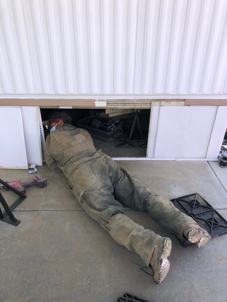 Cal Star technician inspecting under a mobile home