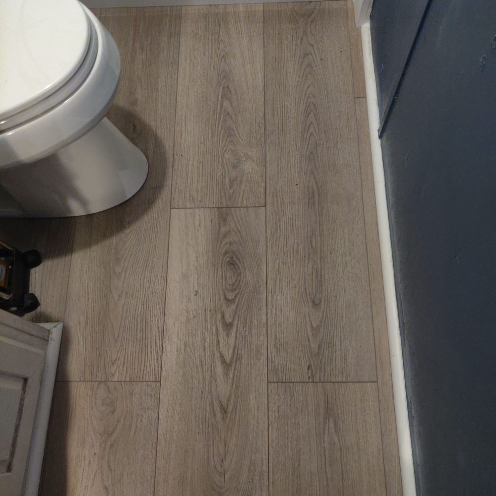 New luxury vinyl plank flooring installed in a mobile home bathroom