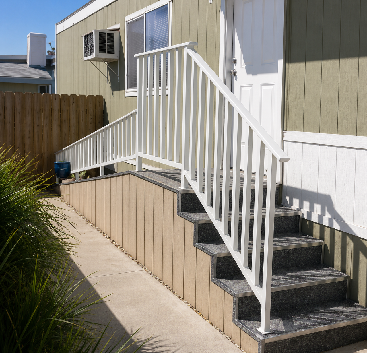 Custom entry ramp and stairs with white railing on a mobile home