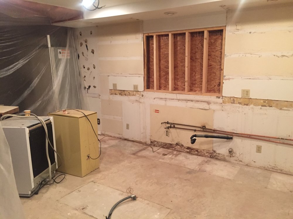 Wall opened for copper supply lines and drain plumbing during a remodel