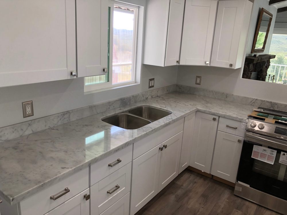 Remodeled mobile home kitchen with marble countertops and new window