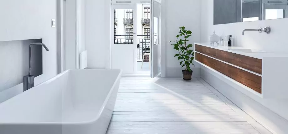 Bright and spacious bathroom with a freestanding bathtub, floating vanity, and natural light from open doors, creating a minimalist and airy design.