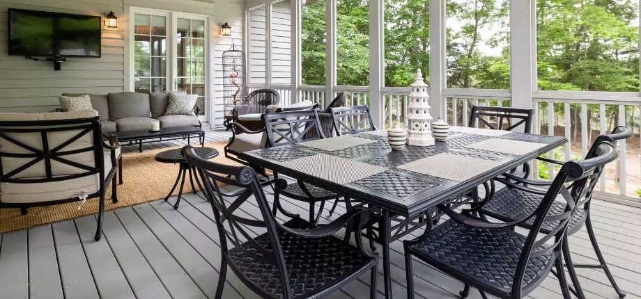 Screened-in porch with a dining table, cozy seating area, and outdoor decor, offering a comfortable and stylish space for relaxation.