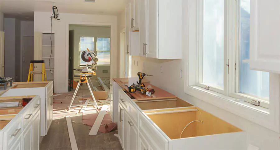 In-progress mobile home kitchen remodel with new white cabinets and space-saving layout in Los Angeles County – tools and materials visible during renovation.