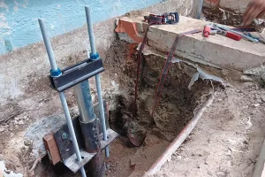 Foundation repair process for slab foundation using helical piers in Carlsbad, demonstrating an effective concrete leveling method for foundation stabilization.