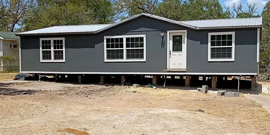 Mobile home elevated for releveling by contractor in Orange County to ensure structural stability and proper alignment